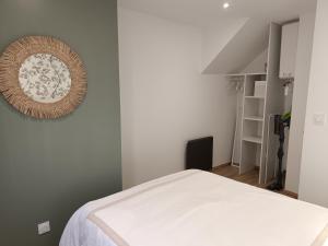 ein Schlafzimmer mit einem Bett und einem Bild an der Wand in der Unterkunft aux nids douillets mayetois "les tourtereaux" in Mayet-de-Montagne