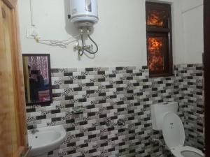 a bathroom with two toilets and a sink and a mirror at Sukham Nest's Limewood Homestay in Rishop