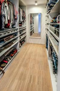ein begehbarer Kleiderschrank mit Holzboden und Spiegel in der Unterkunft Spacious family home 10 min from downtown Ghent in Gent