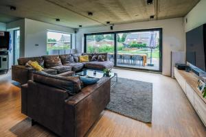 ein großes Wohnzimmer mit einem braunen Ledersofa in der Unterkunft Spacious family home 10 min from downtown Ghent in Gent