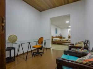 a living room with a table and a bedroom at Casa do sol in Sao Paulo
