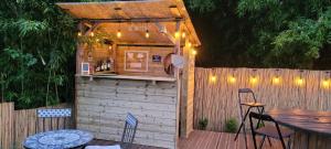 a small building with a bar on a wooden deck at Coquelicots Dordogne in Saint-Julien-de-Lampon