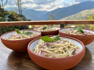 four bowls of pasta on a wooden table at Villa Camila Hostel in Coroico +25 photos