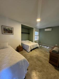 a large bedroom with two beds and a window at Casa pe na areia em Buzios in Búzios +63 photos