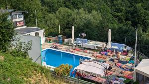 a swimming pool with people lounging next to a resort at Vila N&M in Visoko