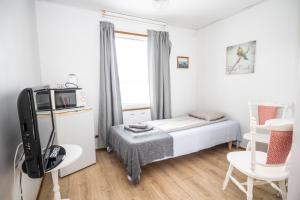 a small bedroom with a bed and a tv at Arctic Guesthouse in Ranua