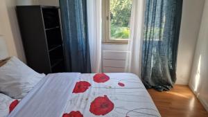 a bedroom with a bed with red flowers on it at Chambre Jardin 1 in Vaujours +2 photos