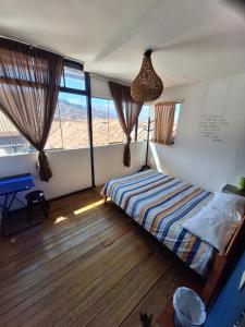 una camera con un letto in una stanza con finestre di Intro Hostels Cusco a Cuzco Altre 37 foto