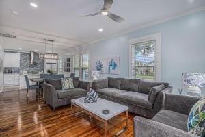 a living room with a couch and a table at Luxury Designer Villa by the Beach Bright Beautiful Brand New in Galveston