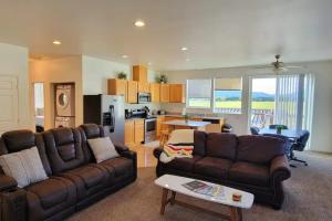 Una sala de estar con dos sofás y una cocina. en Charming Chalet Close to GNP, Downtown & Game Room!, en Columbia Falls