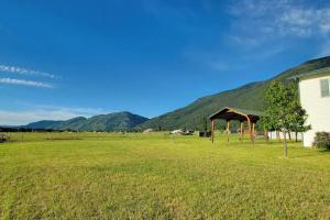 Un campo con una tienda de campaña y una casa y montañas en Charming Chalet Close to GNP, Downtown & Game Room!, en Columbia Falls