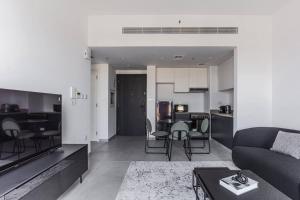 a living room and kitchen with a couch and a table at Sahab - Black Edition One BR Apartment in Sharjah