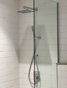 a shower with a glass door in a bathroom at Sahab - Black Edition One BR Apartment in Sharjah