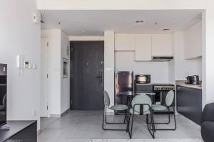 a kitchen and dining room with a table and chairs at Sahab - Black Edition One BR Apartment in Sharjah +18 photos