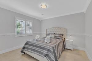a bedroom with a bed with two stuffed animals on it at Tropical Oasis with Heated Pool and BBQ in Tamiami
