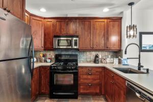 a kitchen with wooden cabinets and a stainless steel refrigerator at Trappers Landing #30 in Sun Peaks