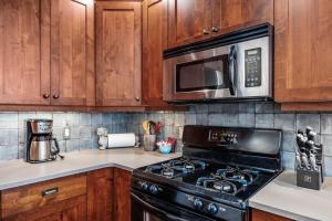 a kitchen with a black stove and a microwave at Trappers Landing #30 in Sun Peaks