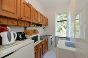 a kitchen with wooden cabinets and a stove top oven at Ambrózia Villa in Balatonfüred