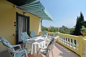 a patio with a table and chairs on a balcony at Ambrózia Villa in Balatonfüred