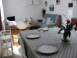 a living room with a table with plates on it at L'Océan pour Voisin, gîte 3 étoiles pour 5 à 6 pers, dans maison, terrasse 34mètres carrés Plage à 1500 m in Tarnos