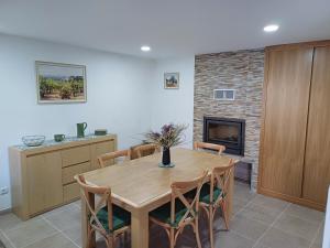 a dining room with a table and a fireplace at Os 3 RRR in Vilela do Tâmega