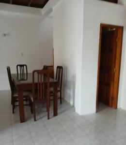 a dining room with a wooden table and chairs at Casa 2 pisos cerca de la playa in Santa Elena +2 photos