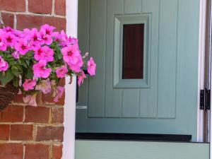 a blue door with pink flowers on a brick wall at The View in Faversham