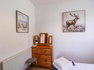 a bedroom with a dresser and a mirror on the wall at The View in Faversham