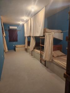 Zimmer mit 3 Etagenbetten in einem Zimmer mit blauen Wänden in der Unterkunft Playa de la Fuente in El Paredón Buena Vista