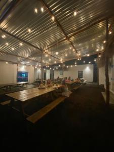 Eine Gruppe von Menschen sitzt auf Bänken in einem großen Raum in der Unterkunft Playa de la Fuente in El Paredón Buena Vista