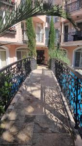 a walkway in front of a building with an iron gate at Апарамент за гости Романс Марин in Sunny Beach