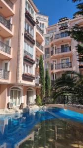 a swimming pool in front of a building at Апарамент за гости Романс Марин in Sunny Beach +16 photos