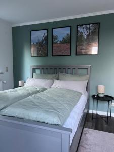 a bedroom with a bed with four pictures on the wall at Ferienwohnung am Pietzmoor in Schneverdingen