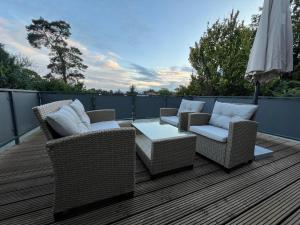 a deck with chairs and a table and an umbrella at Ferienwohnung am Pietzmoor in Schneverdingen