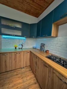 a kitchen with blue cabinets and wooden counters at guest house zizi in Ambrolauri +20 photos