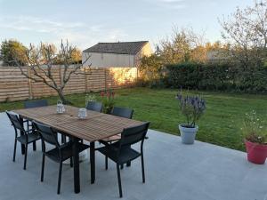 a wooden table and chairs on a patio at Maison de vacances jusqu'à 6 personnes, classée 3 étoiles in Échillais