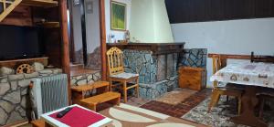 a living room with a stone fireplace and a television at Vila Ami in Kremna