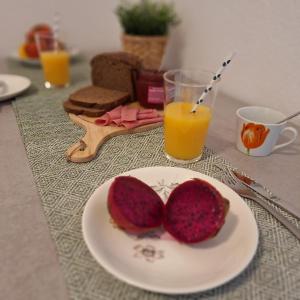 a table with a plate with a piece of bread and orange juice at Apartamento Playa Rosa in Guía de Isora