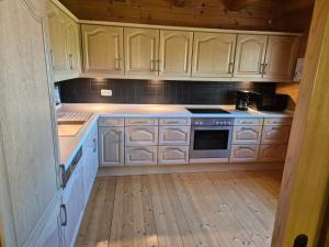 une cuisine avec des armoires blanches et un plancher en bois dans l'établissement Großes gemütliches Chalet im Steigerwald nähe Bamberg, à Lisberg