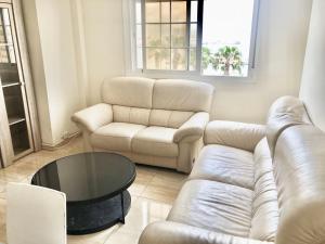 a living room with a leather couch and a table at Marina Vista Puerto in Ceuta