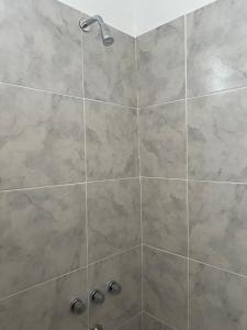 a bathroom with a shower with a large stone tile wall at studios in Cordoba in Cordoba