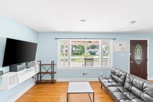 a living room with a couch and a flat screen tv at Charming 3-bedroom house in Wilmington with WiFi, AC in Wilmington