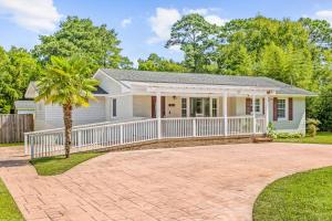 a house with a white fence and a palm tree at Charming 3-bedroom house in Wilmington with WiFi, AC in Wilmington