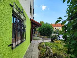 Un edificio verde con una puerta y un jardín. en Green Apartments, en Herbrechtingen