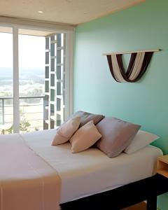 a bedroom with a bed with pillows and a window at Cabañas del cerro 2 in Pichilemu