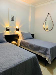 a hotel room with two beds and a mirror at Lory Studio Hotel in São Paulo +22 photos