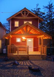 Blockhaus mit einer Veranda und einer weißen Tür in der Unterkunft Reef Point Cottages in Ucluelet