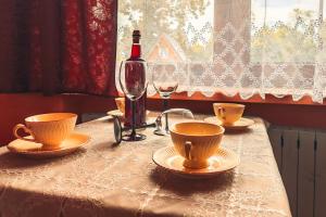 a table with a bottle of wine and a glass at Domek u Stocha in Poronin