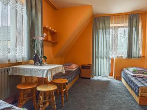 a room with a table and two beds and a window at Domek u Stocha in Poronin