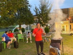 a man playing a flute next to a fire at Guesthouse Dadia in Chʼkhorotsqu